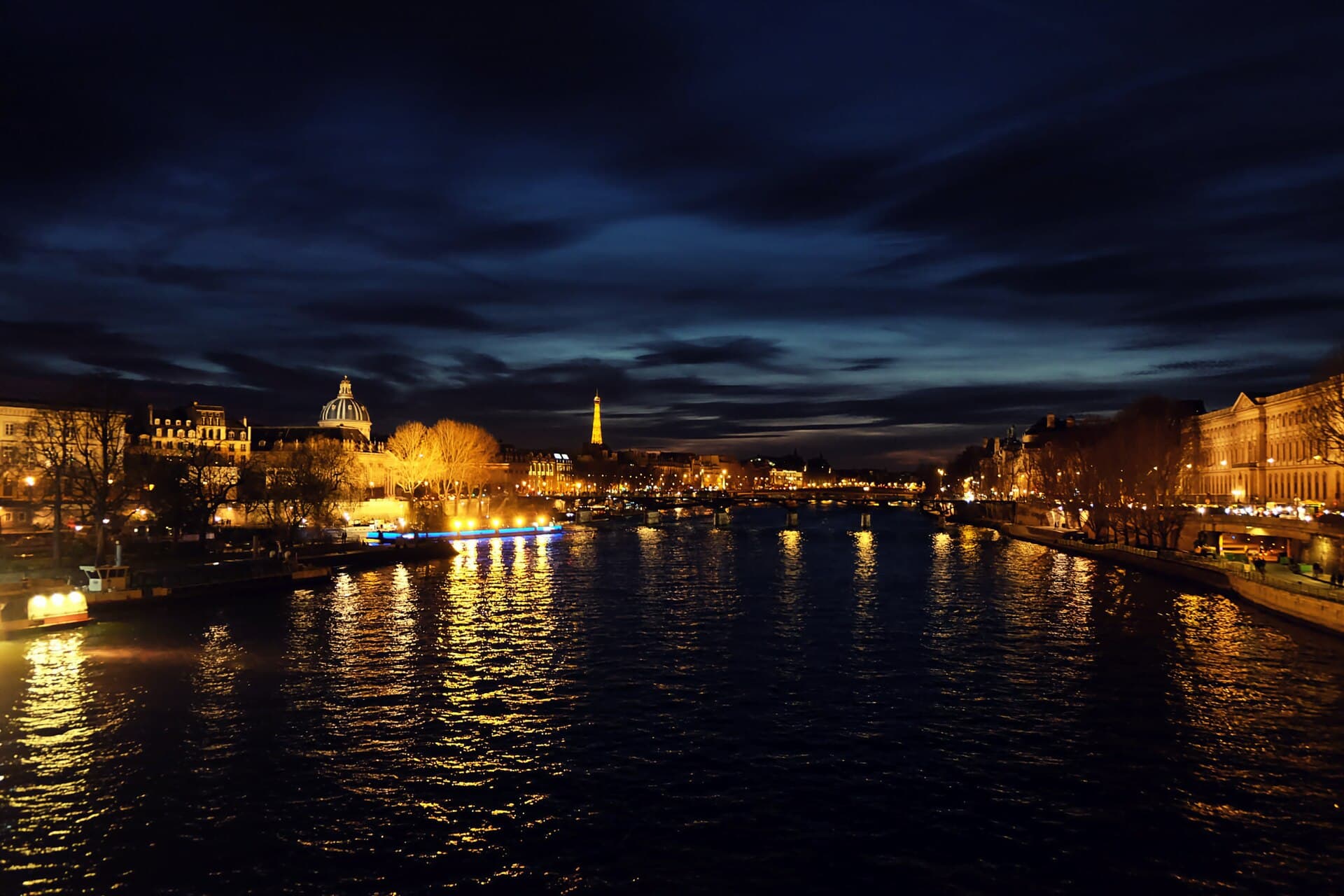 The Seine in Paris at night, with the Eiffel Tower in the distance