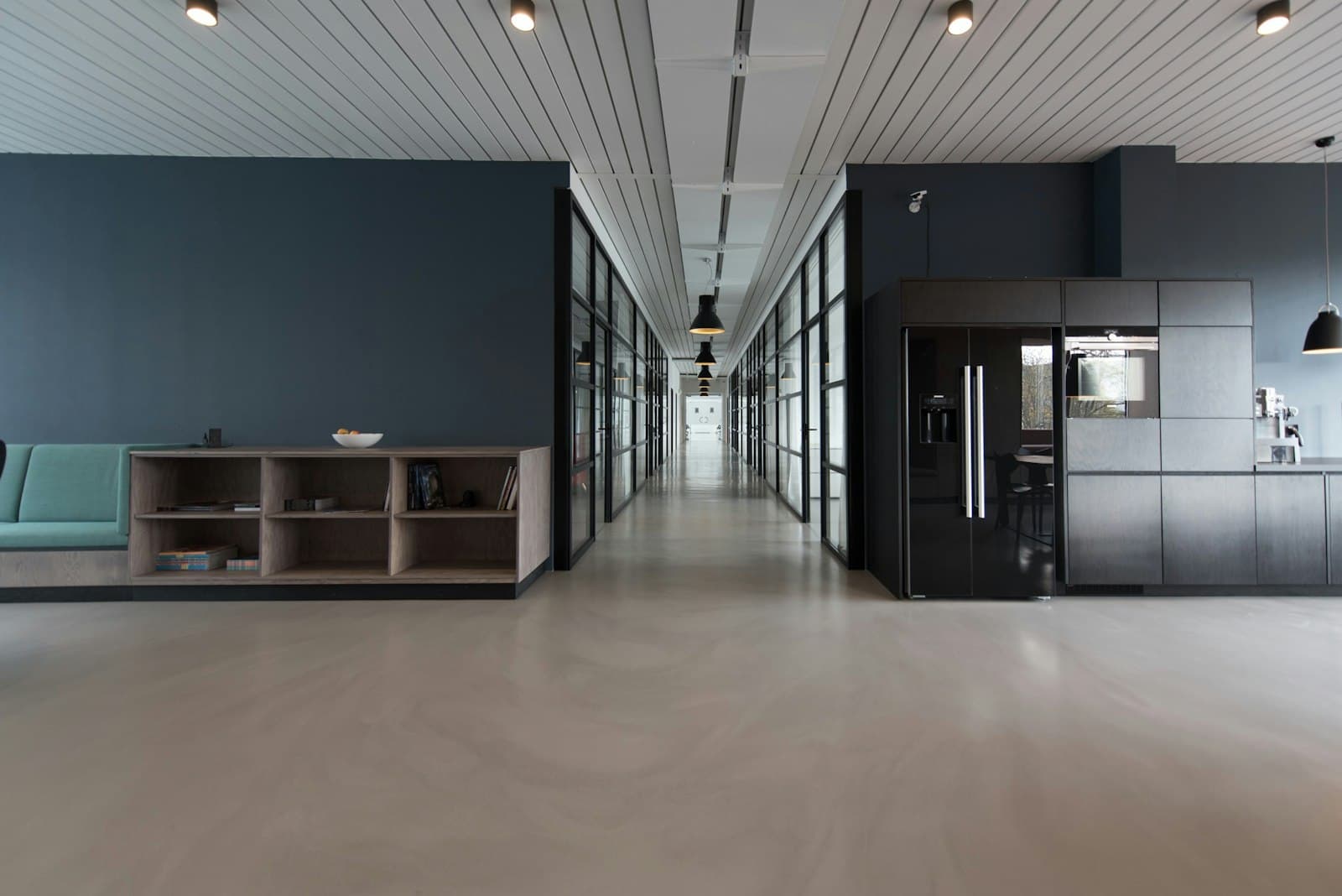 A modern office corridor with glass meeting rooms